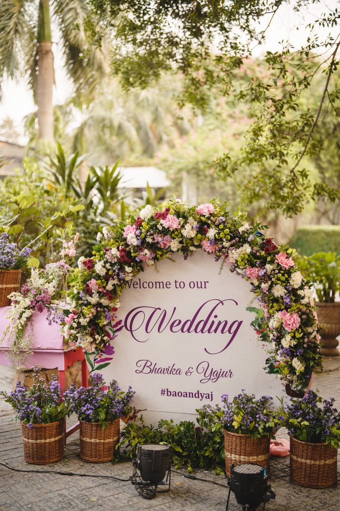 Beautiful floral arch with wedding sign for Bhavika and Yajur in outdoor setting.
