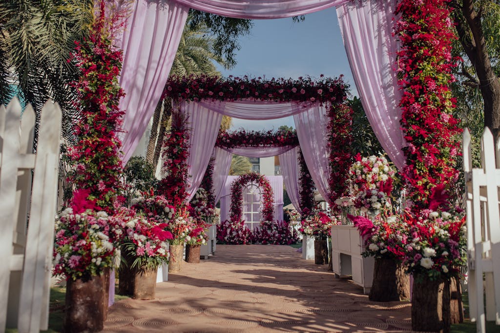 Charming outdoor wedding scene with vibrant floral archways and elegant decor.